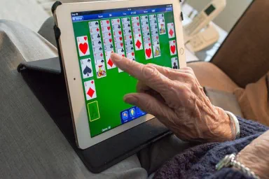 Frau spielt am Tablet Solitär 